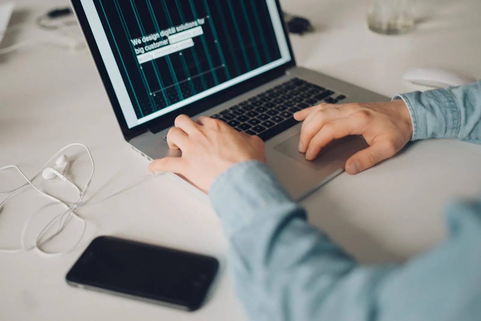 Hands typing on a laptop with code on screen